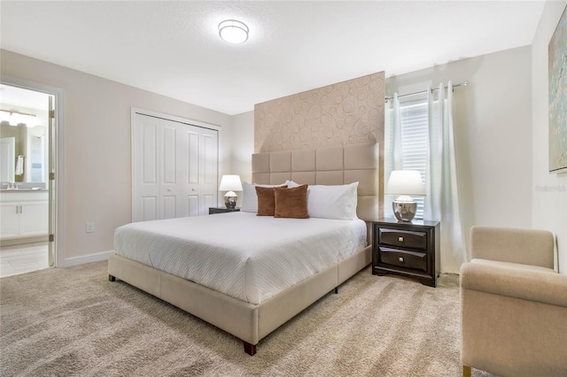 carpeted bedroom with sink, ensuite bath, and a closet