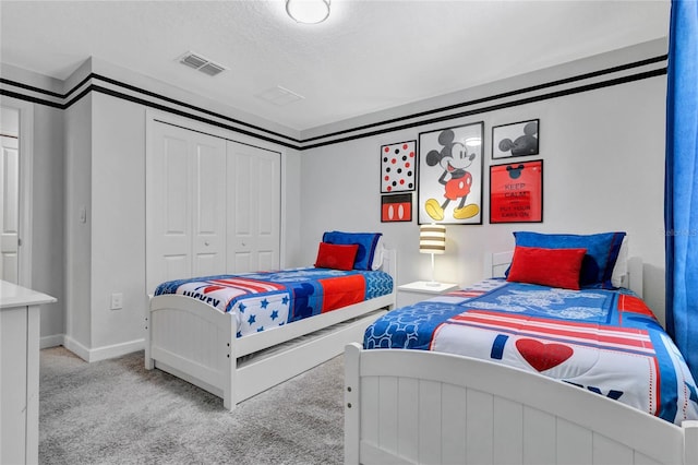 carpeted bedroom featuring a textured ceiling and a closet