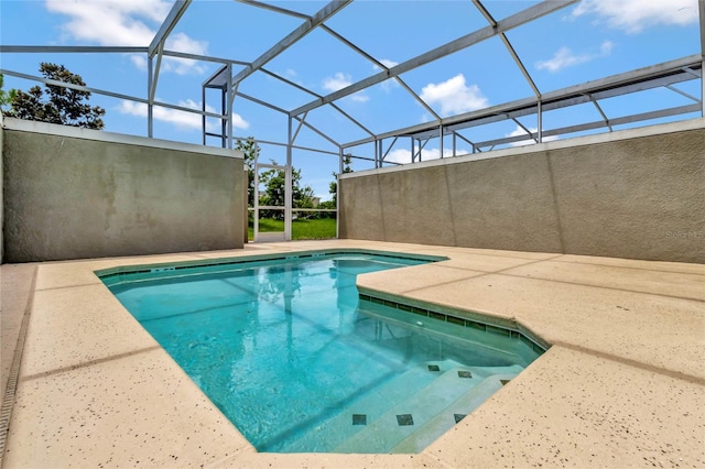 view of swimming pool with a patio area and a lanai