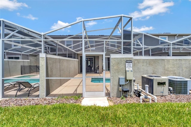 back of house featuring a lanai, cooling unit, and a patio