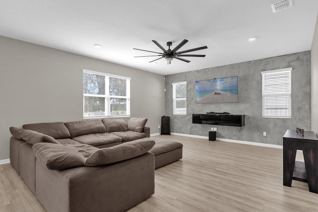 living room with light hardwood / wood-style floors and ceiling fan