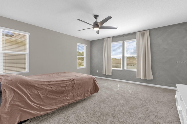 bedroom featuring carpet, multiple windows, and ceiling fan