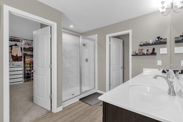 bathroom featuring vanity, a textured ceiling, walk in shower, and wood-type flooring