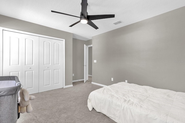 carpeted bedroom featuring a textured ceiling, a closet, and ceiling fan