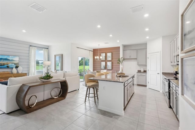 12965 Trovita Dr, Grand Island, FL 32735 - kitchen with stainless steel range with electric cooktop, stone counters, visible vents, a sink, and open floor plan