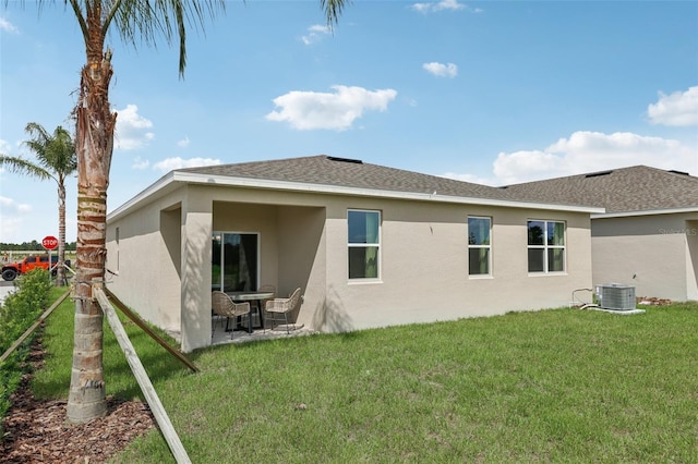 12965 Trovita Dr, Grand Island, FL 32735 - rear view of house featuring roof with shingles, a yard, stucco siding, and central AC