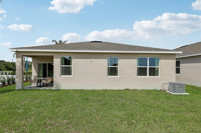 rear view of house featuring central AC, a patio, and a lawn