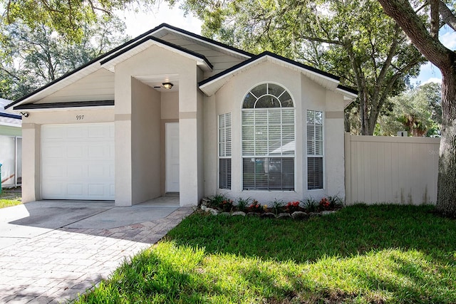 ranch-style house featuring a garage and a front lawn