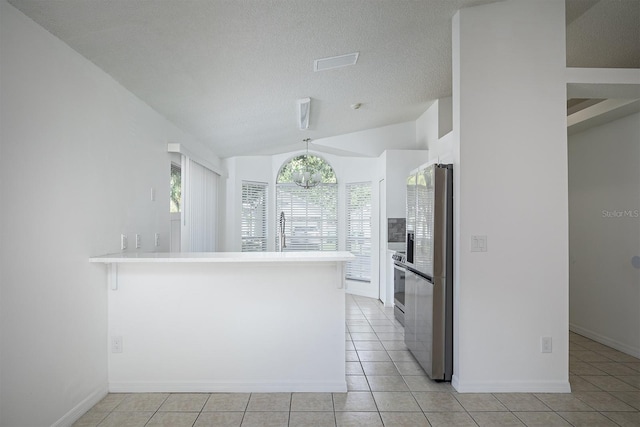 kitchen with lofted ceiling, kitchen peninsula, pendant lighting, stainless steel fridge with ice dispenser, and light tile patterned floors