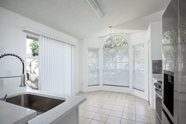 kitchen featuring plenty of natural light, hanging light fixtures, sink, and light tile patterned floors