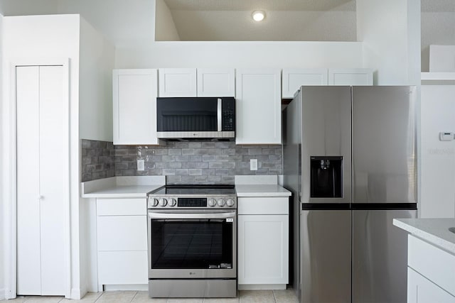 kitchen with white cabinets, a textured ceiling, appliances with stainless steel finishes, and light tile patterned floors