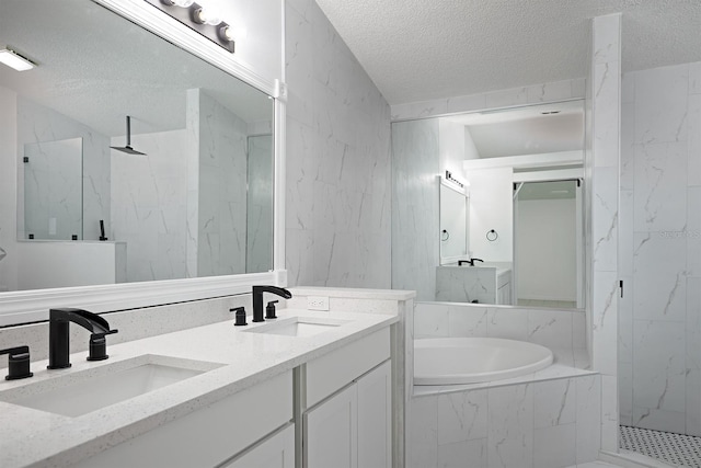 bathroom featuring shower with separate bathtub, vanity, and a textured ceiling