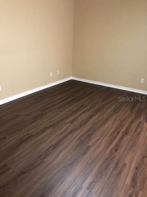 empty room with dark wood-type flooring