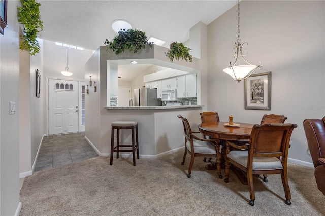 dining area with high vaulted ceiling and carpet