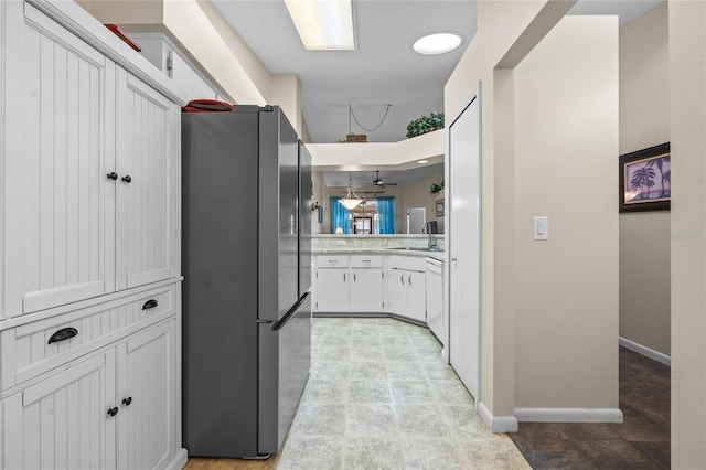 kitchen featuring stainless steel refrigerator, white cabinets, sink, and white dishwasher