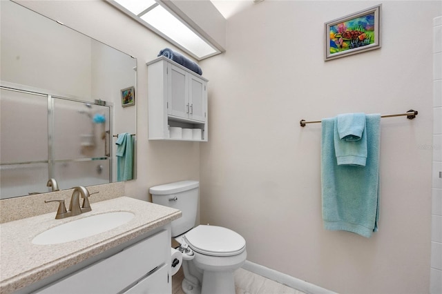 bathroom with vanity, toilet, and an enclosed shower