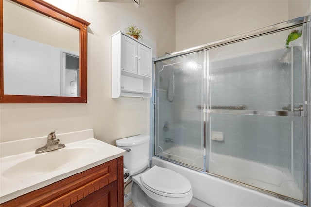 full bathroom featuring shower / bath combination with glass door, toilet, and vanity