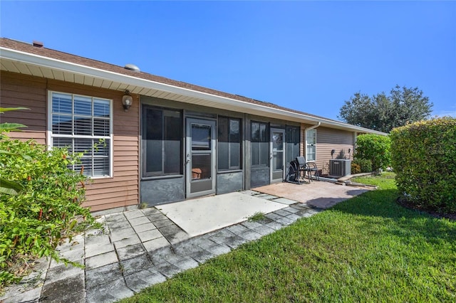 rear view of house with cooling unit, a yard, and a patio