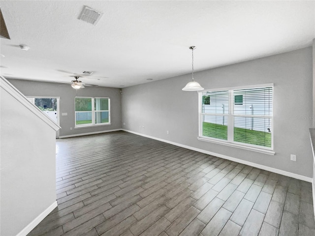 unfurnished living room with dark wood-type flooring and ceiling fan