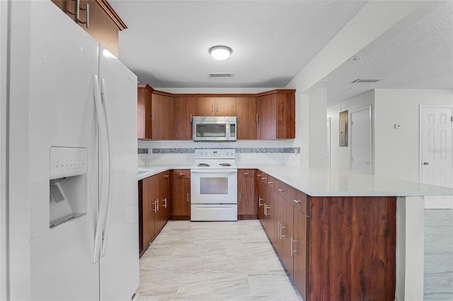 kitchen featuring a textured ceiling, kitchen peninsula, white appliances, and tasteful backsplash