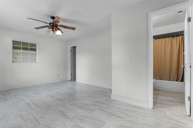 empty room featuring ceiling fan and a textured ceiling