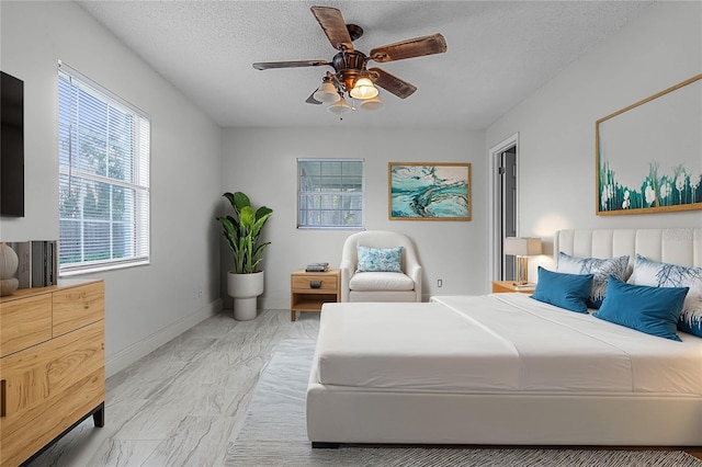 bedroom with a textured ceiling and ceiling fan