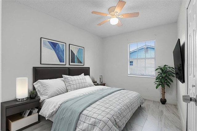 bedroom featuring ceiling fan and a textured ceiling