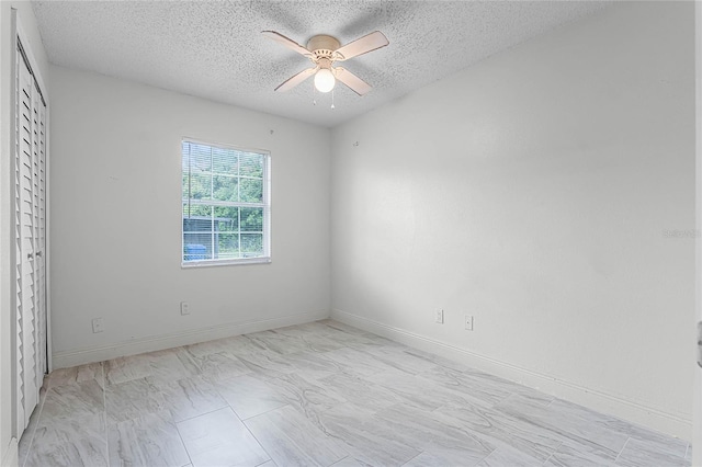 unfurnished room featuring ceiling fan and a textured ceiling