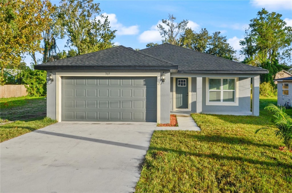 single story home with a garage and a front lawn