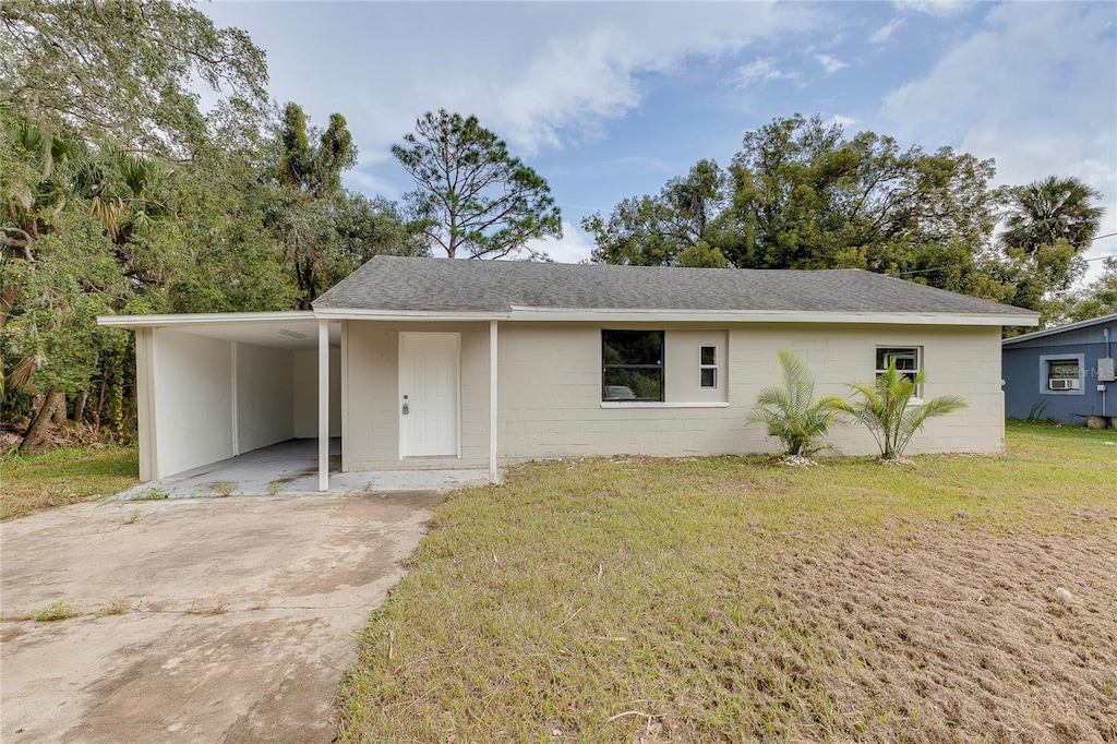 ranch-style house with a front yard and a carport