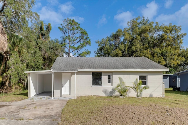 ranch-style house with a front yard and a carport