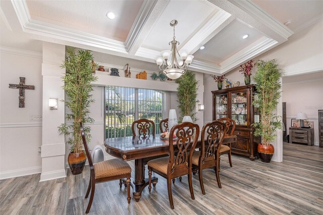 dining room featuring crown molding, wood-type flooring, and a notable chandelier