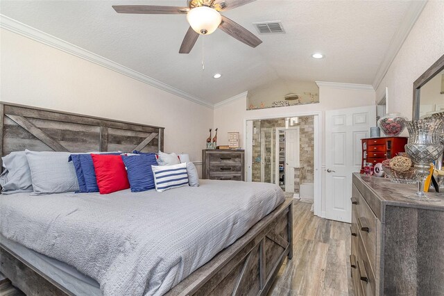 bedroom with ornamental molding, a textured ceiling, ceiling fan, light hardwood / wood-style floors, and lofted ceiling