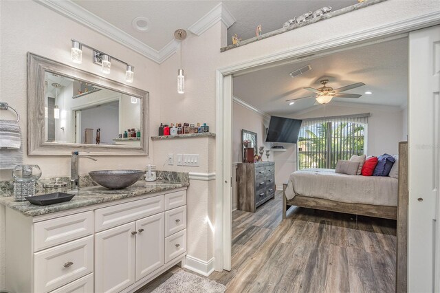 bathroom featuring ceiling fan, crown molding, wood-type flooring, lofted ceiling, and vanity