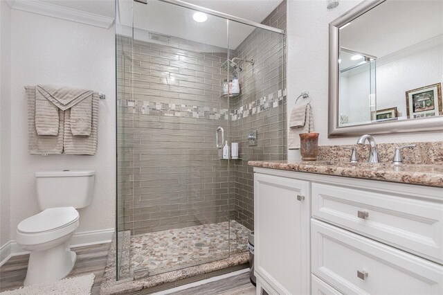 bathroom featuring walk in shower, crown molding, toilet, vanity, and hardwood / wood-style flooring