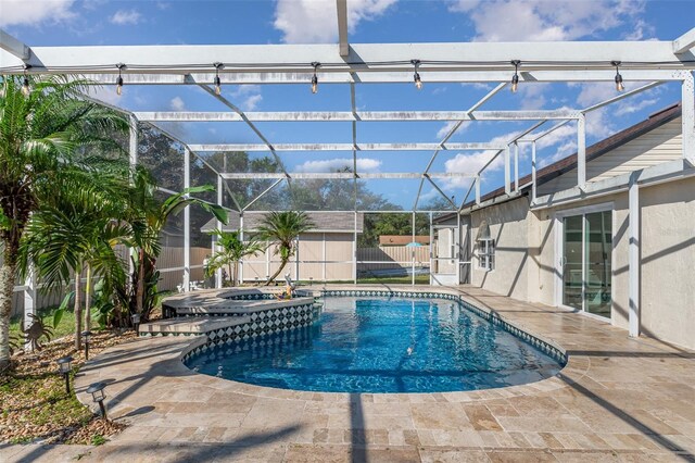 view of swimming pool with an in ground hot tub, a patio, and a shed