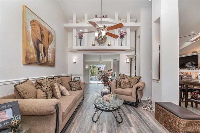 living room with hardwood / wood-style floors, ceiling fan, and ornamental molding