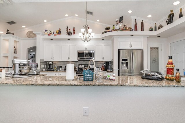 kitchen with crown molding, white cabinets, stainless steel appliances, and lofted ceiling