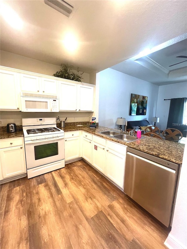 kitchen with kitchen peninsula, white appliances, and white cabinets