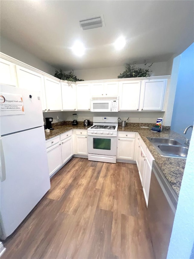 kitchen featuring dark hardwood / wood-style flooring, white appliances, sink, and white cabinets