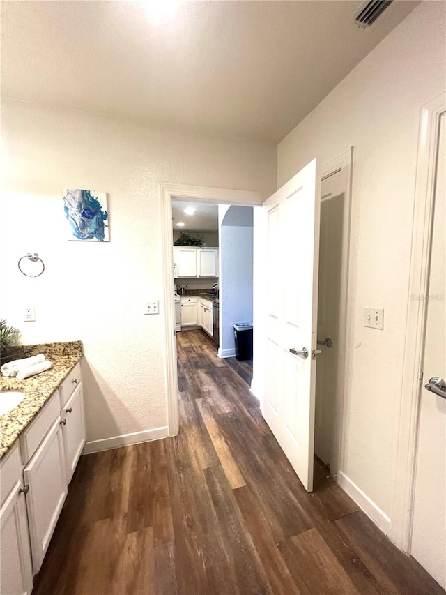 hall with sink and dark wood-type flooring