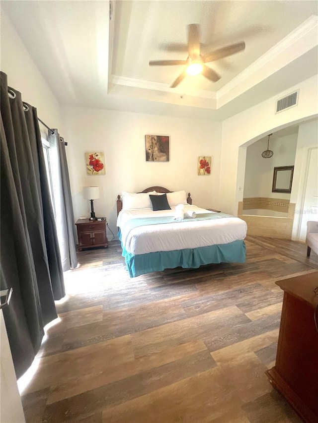 bedroom with ceiling fan, a raised ceiling, and dark hardwood / wood-style floors