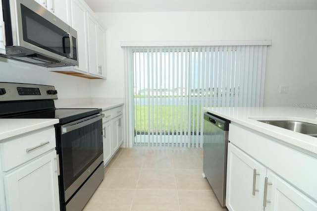 kitchen with white cabinets, light tile patterned flooring, and appliances with stainless steel finishes