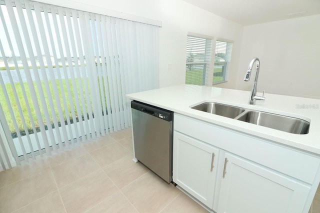 kitchen with dishwasher, white cabinets, sink, and light tile patterned floors