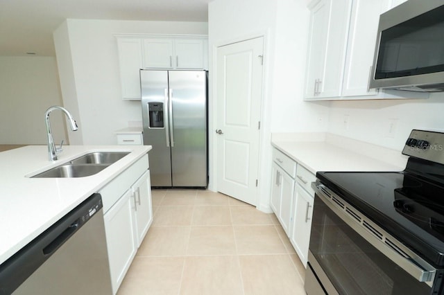 kitchen featuring white cabinets, light tile patterned flooring, stainless steel appliances, and sink