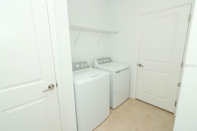 clothes washing area with separate washer and dryer and light tile patterned floors