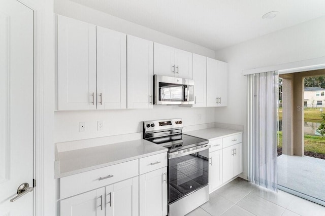 kitchen with white cabinetry, appliances with stainless steel finishes, and light tile patterned flooring