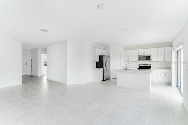 kitchen featuring white cabinetry, appliances with stainless steel finishes, a kitchen island with sink, and sink