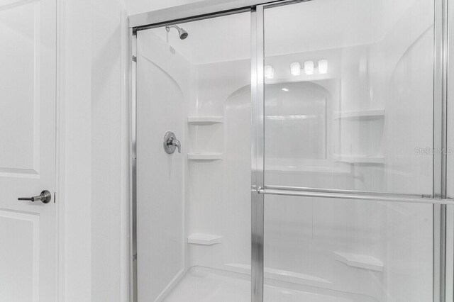 bathroom featuring a shower with shower door