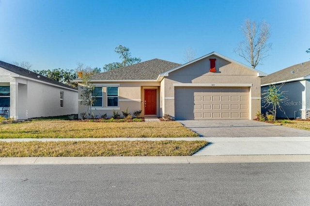 ranch-style house featuring a garage and a front yard